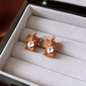Macro shot of cute brown elephant stud earrings with heart crystal in a jewelry box