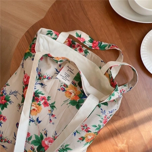 Détail d'un sac cabas en toile à fleurs avec étiquette tissée et doublure douce