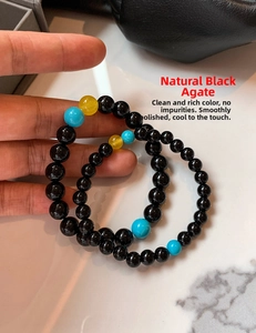 Macro shot of natural black agate beads bracelet with blue and yellow accents