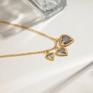Detailed macro view of three heart pendants with silver mirrors and gold beaded borders