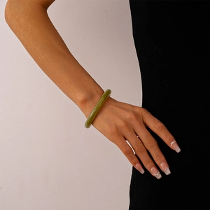 Detail view of a vintage emerald green acrylic open bangle with translucent marble texture