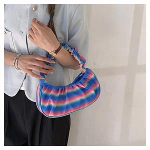 Rainbow gradient pleated shoulder bag showing colorful stripes on a cloud-style dumpling bag