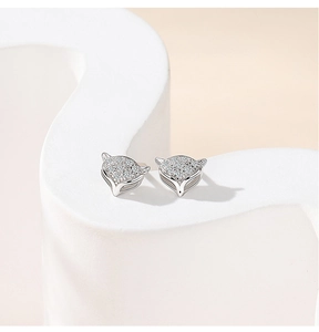 Macro shot of silver fox-shaped stud earrings with sparkling stones on display