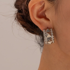 Silver stainless steel C-shaped stud earrings with punk studs on a female model
