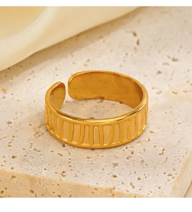 Vista dettagliata dell'anello regolabile placcato oro 18K con strisce verticali su marmo