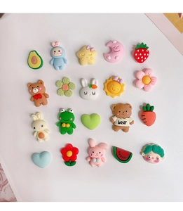 Flat lay macro view of twenty assorted colorful 3D resin cartoon charms for DIY decoration