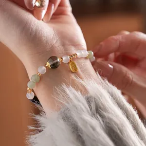 Green phantom quartz and tiger eye beaded bracelet with a golden Fu lucky charm