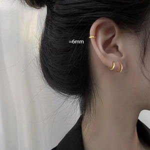 Close-up of stylish 6mm gold geometric hoop earrings and ear cuffs on a model