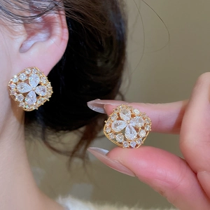 Detailed macro view of 18K gold plated flower stud earrings with brilliant zircon stones