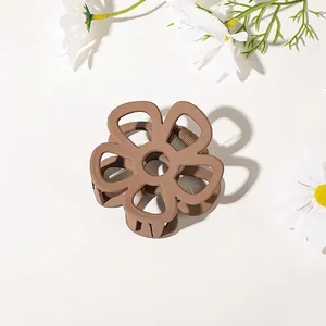 Close-up of a matte brown flower hair claw clip with fresh white daisy decorations