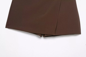 Detailed close-up of dark brown asymmetric skort hem with professional double stitching