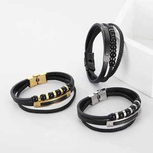 Close-up of multilayer leather bracelets with black, gold, and silver stainless steel beads
