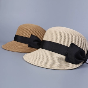 Dettaglio di cappelli di paglia beige e cammello con eleganti fiocchi in nastro nero