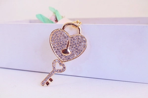 Close-up of golden heart lock and key keychain with sparkling rhinestones details