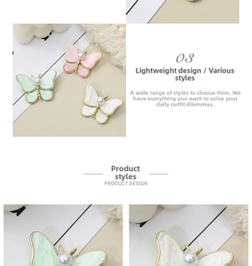 Macro detail of butterfly pearl brooches in pink, green, and white enamel finish