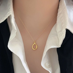 Minimalist 925 silver golden teardrop pendant necklace worn by a model in a close-up view