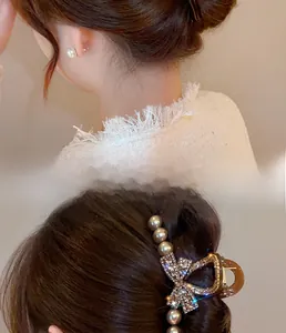 Detail of vintage amber resin shark clip with bow rhinestones and pearls on hair