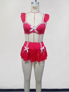 Detailansicht des roten Satin-Lingerie-Sets mit weißem Spitzenbesatz und Schleifenakzenten