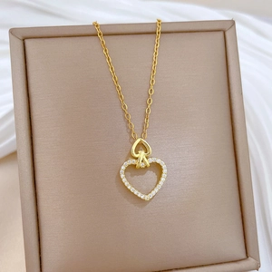 Close-up of golden double heart pendant with sparkling crystals in a premium gift box