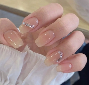 Macro detail of nude gradient press-on nails with silver rhinestones and zircons