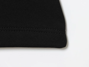 Detailed close-up of double-needle stitched hem on black knit flare pants set