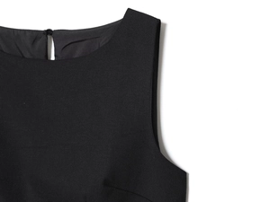 Dettaglio del lino nero con scollo rotondo e chiusura a goccia con bottone sul retro