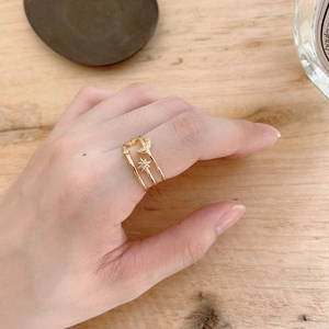 Detailed view of layered 925 silver rings with star and moon charms on model's hand