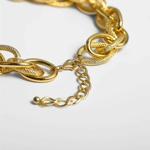 Close-up of golden aluminum chain necklace with textured oval links and lobster clasp