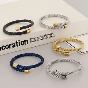 Five stylish twisted stainless steel cable cuff bracelets in gold, silver, black, and blue