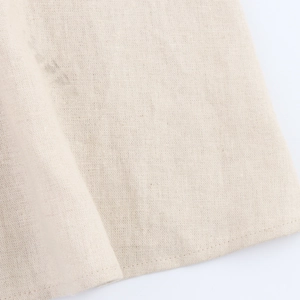 Detailed macro shot of beige linen fabric texture and fine stitching on casual dress