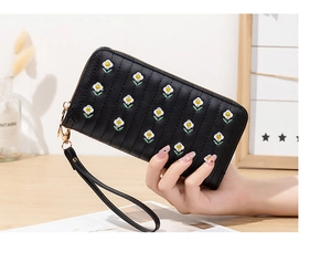 Close-up of black PU leather long wallet with white daisy floral embroidery and wrist strap