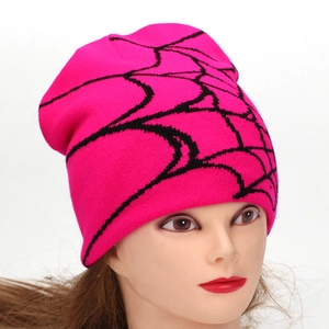 Hot pink beanie with black spider web pattern shown on a model head for winter warmth
