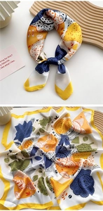 Detail of a tropical floral silk scarf with vibrant yellow and blue botanical patterns