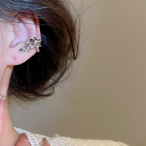 Détail d'une manchette d'oreille en or en forme d'étoile avec des strass blancs