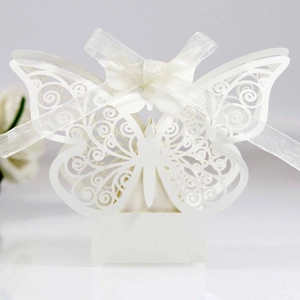 Elegant laser-cut butterfly wedding favor box in white pearlescent paper with ribbon