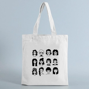 White canvas tote bag with black line cartoon face print on a light blue background
