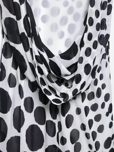 Detail of elegant black and white polka dot chiffon dress with draped neckline texture