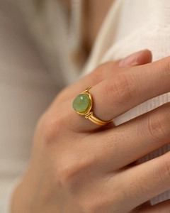 Close-up of a vintage gold titanium ring with a polished green semi-precious oval stone