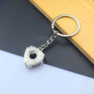 Close-up of a silver rotary engine rotor keychain with a polished metallic finish