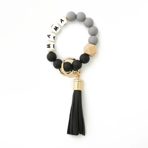 Detailed view of MAMA silicone bead keychain bracelet with grey beads and black tassel