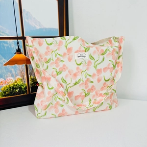 Detailed close-up of a floral canvas tote bag featuring pink flowers and green leaves pattern