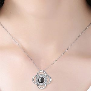 Detail of silver clover projection necklace with black gemstone and sparkling crystals
