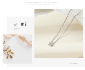 Macro detail of silver star pendant with pave micro-diamonds on a slim O-chain necklace