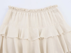 Detail of cream tiered midi skirt featuring elastic waist and ruffled fabric layers