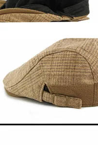 Detail view of brown plaid wool beret with metal adjustment buckle and texture