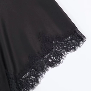 Detailed view of black satin fabric with intricate eyelash lace trim for a luxury feel