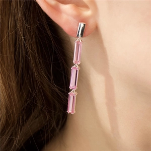 Detail of sterling silver tassel earrings featuring three pink rectangular crystals