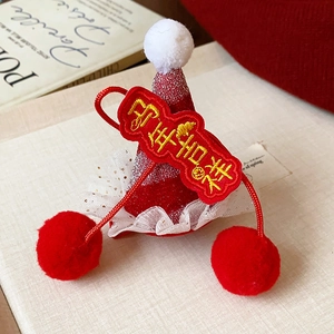Détail d'une pince à cheveux de Nouvel An rouge pailleté avec pompons et broderie