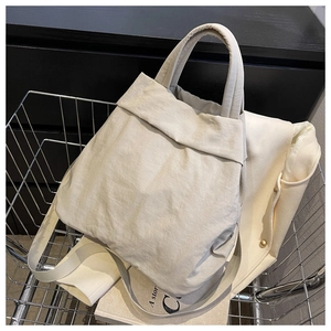 Detailed texture of a cream-white nylon shoulder bag placed inside a metal wire basket