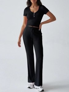 Dettaglio di un set Y2K nero con t-shirt con scollo a U e pantaloni con coulisse